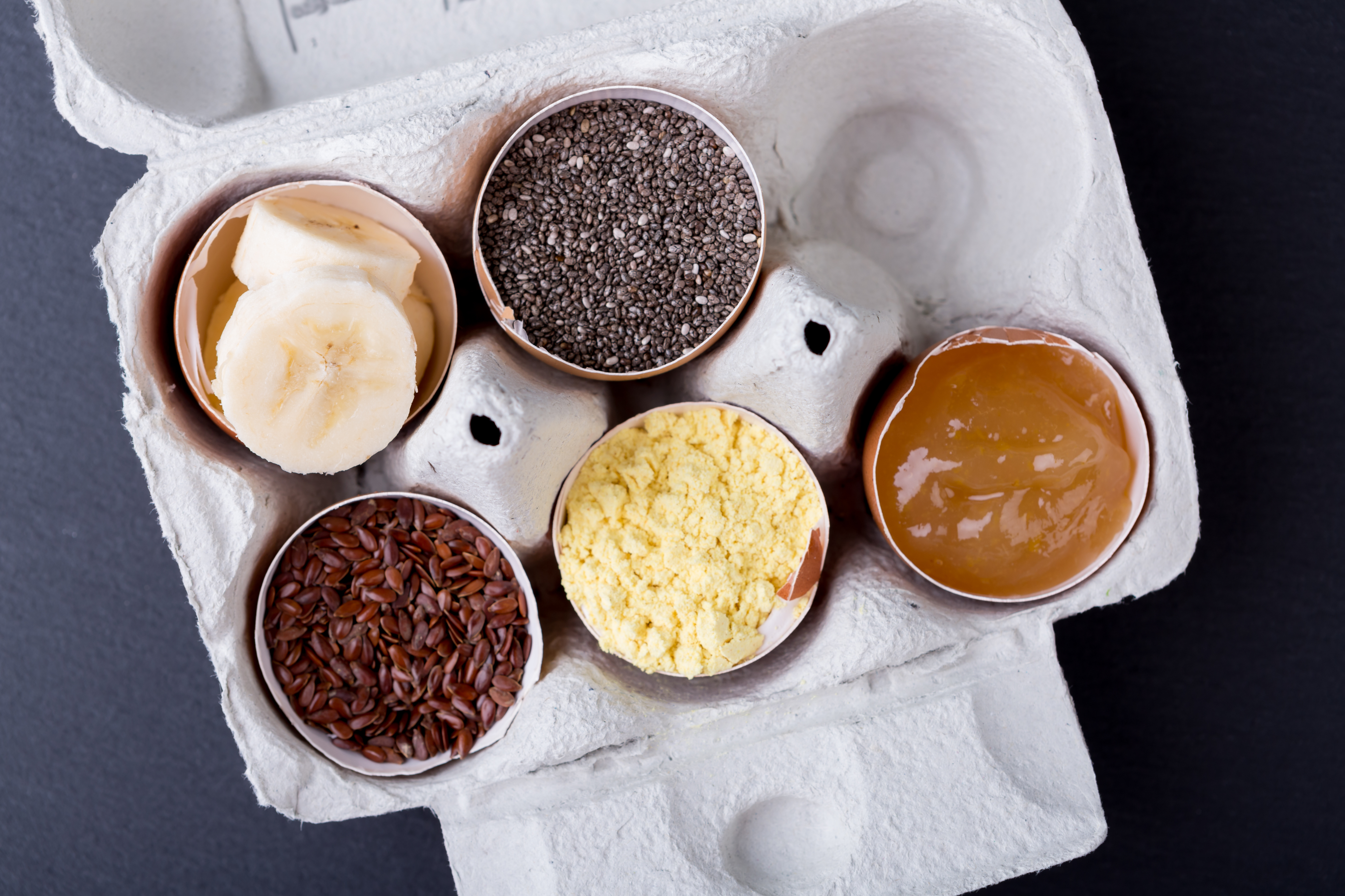 Egg subtitues like flax, chia, and bananas in open egg shells.