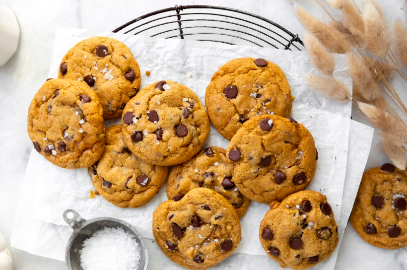Chocolate chip pumpkin cookies on parchment paper.