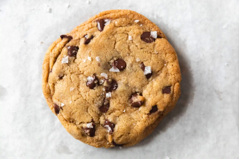 Single chocolate chip cookie on parchment paper.